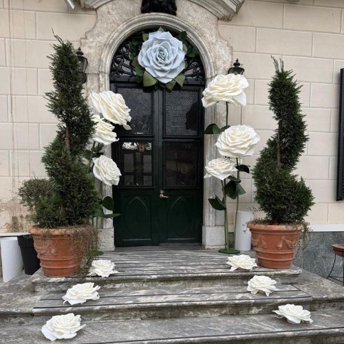 Rose giganti bianche installate su scala d’ingresso di una villa storica, scenografia floreale artistica per matrimonio.